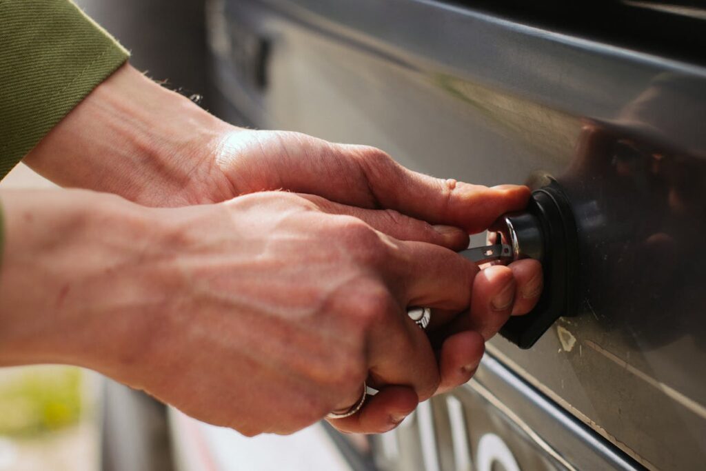 A hand with keys trying to opening car trunk